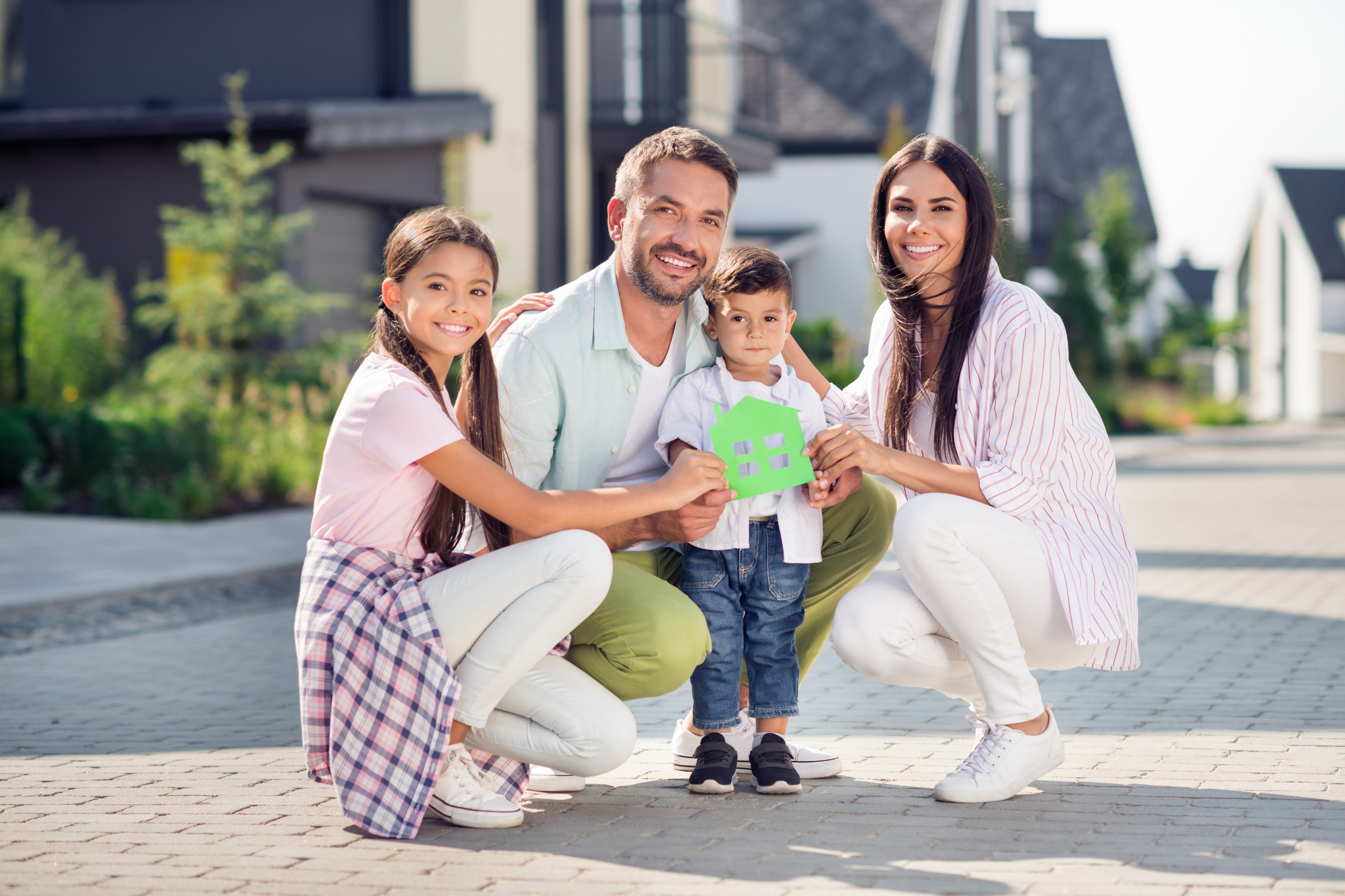 Young family with kids holding a model home