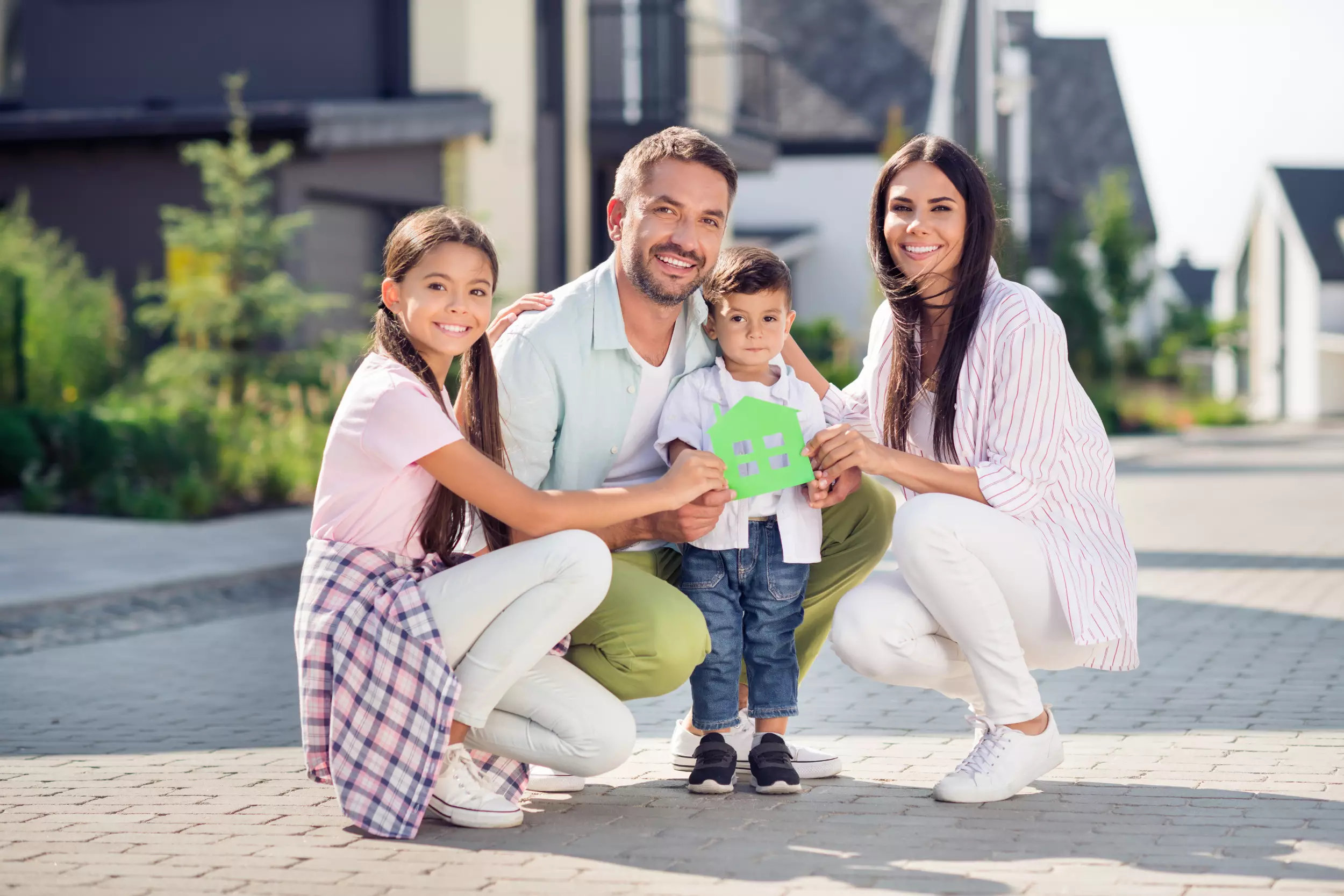 Young family with kids holding a model home